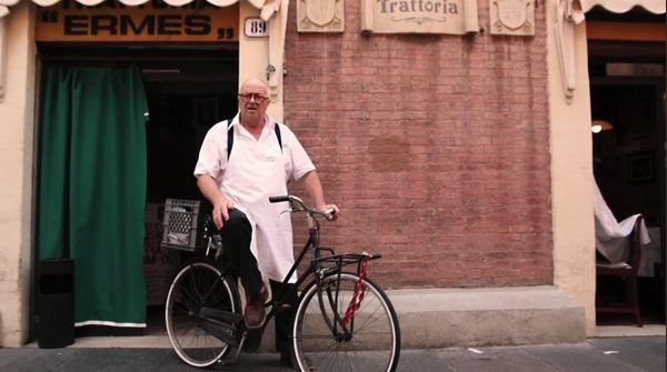 Ermes appoggiato alla sua bicicletta davanti alla trattoria